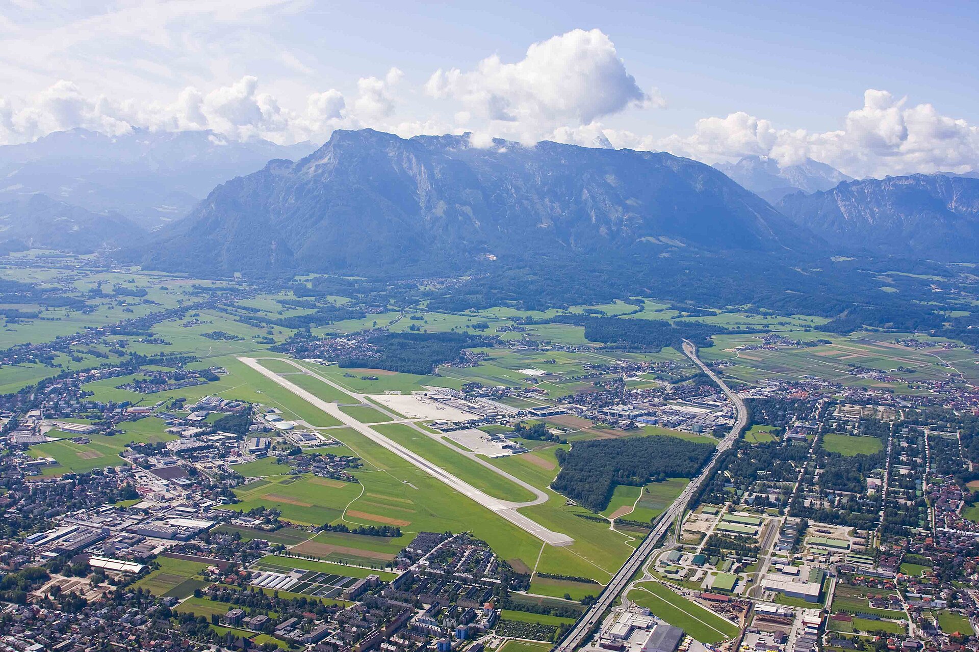Luftaufnahme des Salzburg Airport (SZG) mit Terminal, Vorfeld und Landebahn