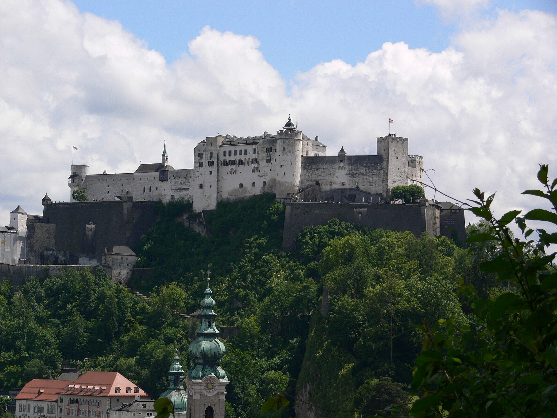 Blick auf die Salzburger Altstadt mit Kirchtürmen und den Alpen im Hintergrund